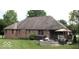 A brick home's backyard offers a patio with a hot tub, outdoor seating, and a cozy fire pit at 2731 Trailridge Ct, Martinsville, IN 46151