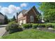 Brick home featuring a two-car garage, beautiful landscaping, and green lawn at 2750 Joshua Dr, Carmel, IN 46033
