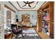 Cozy home office featuring custom built-in shelves, tray ceiling, a window, and natural light at 2750 Joshua Dr, Carmel, IN 46033