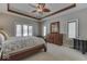 Serene bedroom features tray ceilings, wood trim and a large window offering natural light and scenic views at 2861 Shadwell Pl, Greenwood, IN 46143