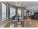 Bright dining area featuring a glass table, modern chairs, and hardwood floors adjacent to the living area at 2861 Shadwell Pl, Greenwood, IN 46143