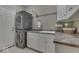 Functional laundry room with stacked washer and dryer, built-in cabinets, and a utility sink for added convenience at 2861 Shadwell Pl, Greenwood, IN 46143