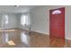 Bright living room featuring gleaming hardwood floors and a striking red front door at 3044 S Keystone Ave, Indianapolis, IN 46237