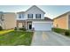 Two-story home featuring a brick and vinyl facade, attached two-car garage, and well-manicured lawn at 3153 Underwood Dr, Whiteland, IN 46184
