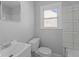 A bright bathroom with a single sink and a toilet under the window at 3701 N Temple Ave, Indianapolis, IN 46218