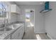 Updated kitchen featuring stainless steel sink, granite counters, subway tile backsplash, and laminate flooring at 3701 N Temple Ave, Indianapolis, IN 46218