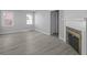Bright living room featuring laminate flooring, two windows, a fireplace, and fresh paint at 3701 N Temple Ave, Indianapolis, IN 46218