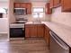 Functional kitchen featuring stainless steel appliances, wood cabinets, and laminate counters at 3743 Celtic Dr, Indianapolis, IN 46235