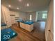 Bright kitchen with a large island, neutral walls, white cabinets, and laminate wood flooring at 3912 Bamboo Branch Dr, Clayton, IN 46118