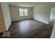 Spacious living room with a large window, neutral walls, and laminate wood flooring at 3912 Bamboo Branch Dr, Clayton, IN 46118