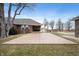 Backyard featuring a large patio area perfect for entertaining and a view of the brick home and surrounding trees at 3949 W 250 N, Anderson, IN 46011