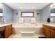 Bright bathroom featuring a vanity, a bathtub, neutral walls, tile flooring, and a window at 3949 W 250 N, Anderson, IN 46011