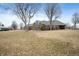 Wide shot of brick home featuring large windows and a well manicured front lawn and surrounding trees at 3949 W 250 N, Anderson, IN 46011