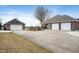 Exterior shot of brick home featuring multiple garages, a long driveway, and well-kept lawn at 3949 W 250 N, Anderson, IN 46011
