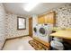 Spacious laundry room with washer, dryer, cabinets, sink, and charming, patterned wallpaper at 3949 W 250 N, Anderson, IN 46011