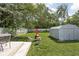 Spacious backyard with a red outdoor fireplace, metal storage shed, and a wooden deck at 4429 Crittenden Ave, Indianapolis, IN 46205
