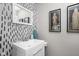 Stylish bathroom featuring a modern vanity, decorative mirror, and chic wallpaper at 4429 Crittenden Ave, Indianapolis, IN 46205