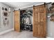 Bedroom closet with sliding barn doors and built-in shelving and clothing racks at 4429 Crittenden Ave, Indianapolis, IN 46205