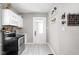 Galley kitchen featuring stainless steel appliances, white cabinets, and decorative backsplash at 4429 Crittenden Ave, Indianapolis, IN 46205