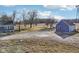 Exterior view of property featuring blue house, matching outbuilding with red door, and surrounding landscape at 4844 N 700 W, McCordsville, IN 46055