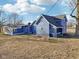 The blue farmhouse exterior is showcased, highlighting its unique color and architecture at 4844 N 700 W, McCordsville, IN 46055