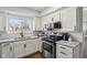 Updated kitchen boasts white cabinets, modern appliances, and granite countertops at 4844 N 700 W, McCordsville, IN 46055