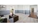 Bright living room with gray paneled walls, gray carpet, and view to bedroom at 4844 N 700 W, McCordsville, IN 46055