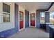 Welcoming covered porch featuring red doors, white trim, and modern brickwork, creating a cozy entrance at 4844 N 700 W, McCordsville, IN 46055