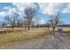 Expansive grassy yard with mature trees under a partly cloudy sky, featuring a large propane tank at 4844 N 700 W, McCordsville, IN 46055