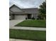 Charming single-story brick home with a well-manicured lawn and an attached two-car garage at 5002 Delray Dr, Columbus, IN 47203
