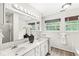 This bathroom has a double sink vanity, updated lighting, and decorative wallpaper at 5014 Melbourne Rd, Indianapolis, IN 46228