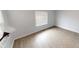 A bright bedroom with neutral walls, wood-look floors, and a sunny window at 5014 Melbourne Rd, Indianapolis, IN 46228