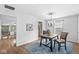 Dining room features hardwood floors, modern chandelier, view to other rooms, and a rustic wood dining table at 5014 Melbourne Rd, Indianapolis, IN 46228