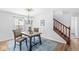 Dining room has wood floors, contemporary chandelier, and a view to the stairway with wood banister at 5014 Melbourne Rd, Indianapolis, IN 46228