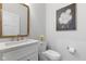 Stylish half-bathroom featuring modern fixtures, a gold-framed mirror, and a decorative flower arrangement at 5189 Abbeygate Blvd, Bargersville, IN 46106