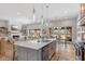 Modern kitchen with white island, stainless steel appliances, and an open floor plan overlooking the living area at 5189 Abbeygate Blvd, Bargersville, IN 46106