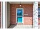 Close-up of the front door with brick surround and a decorative light fixture at 5402 Basin Park Dr, Indianapolis, IN 46239
