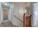 Upstairs hallway features neutral carpeting, wood railing and decorative light fixture at 5402 Basin Park Dr, Indianapolis, IN 46239