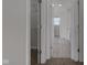 Hallway featuring neutral carpet leading to a closet and bathroom with vinyl floor at 5402 Basin Park Dr, Indianapolis, IN 46239