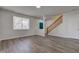 Bright living room with wood floors, neutral walls, stairs, and teal entry door at 5402 Basin Park Dr, Indianapolis, IN 46239