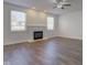 Bright living room featuring a fireplace, ceiling fan and beautiful dark brown hardwood floors at 5402 Basin Park Dr, Indianapolis, IN 46239