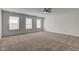 The expansive main bedroom features neutral carpet, a ceiling fan and lots of natural light at 5402 Basin Park Dr, Indianapolis, IN 46239
