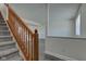 Carpeted staircase with wood railing and neutral walls leading to the living area at 5402 Basin Park Dr, Indianapolis, IN 46239