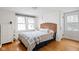 Bedroom with wooden floors, decorative headboard, two windows and a modern dresser at 5426 Broadway St, Indianapolis, IN 46220
