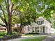 Traditional home featuring a well-manicured lawn and mature trees providing shade and curb appeal at 5426 Broadway St, Indianapolis, IN 46220
