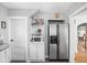Kitchen featuring built-in shelves, stainless steel refrigerator and white door at 5426 Broadway St, Indianapolis, IN 46220