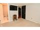 Neutral carpeted bedroom with TV, black door, and adjacent tiled bathroom at 5855 Dapple Trce, Indianapolis, IN 46228