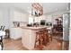 Kitchen island with wooden stools, overhead pot rack, and white cabinetry at 5855 Dapple Trce, Indianapolis, IN 46228