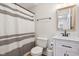 Well-lit bathroom with a framed mirror, modern sink, and striped shower curtain at 6024 N County Road 50 W, Lizton, IN 46149
