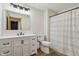 Modern bathroom featuring white vanity, black hardware, patterned shower curtain, toilet, and wood-look flooring at 6024 N County Road 50 W, Lizton, IN 46149